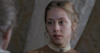 Movie still from “Pelle the Conqueror” (1987), directed by Bille August – A young woman wearing a brown dress with a white collar; Close Up shot, Over the shoulder angle