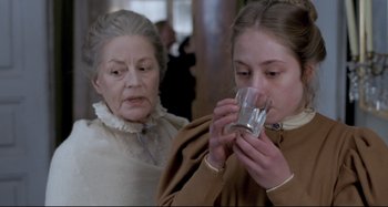 Movie still from “Pelle the Conqueror” (1987), directed by Bille August – A woman and an older woman drinking from a glass; Close Up shot, Over the shoulder angle