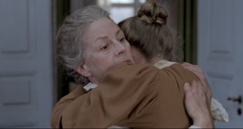 Movie still from “Pelle the Conqueror” (1987), directed by Bille August – An older woman hugging a younger woman in a room; Close Up shot, Over the shoulder angle