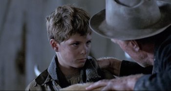 Movie still from “Pelle the Conqueror” (1987), directed by Bille August – A young boy looking at an older man; Close Up shot, Over the shoulder angle