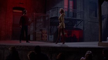 Movie still from “Pepe” (1960), directed by George Sidney – A woman walking on a stage in front of a crowd of onlookers; Wide shot, Low angle