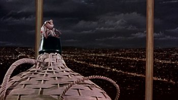 Movie still from “Pepe” (1960), directed by George Sidney – A frog sitting on top of a basket on top of a building; Wide shot, Low angle