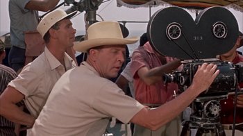 Movie still from “Pepe” (1960), directed by George Sidney – A man in a cowboy hat is holding a camera; Medium shot, Low angle