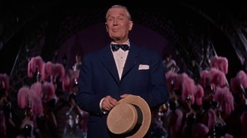 Movie still from “Pepe” (1960), directed by George Sidney – An older man in a suit and bow tie holding a straw hat; Medium shot, Low angle