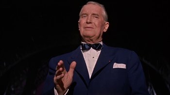 Movie still from “Pepe” (1960), directed by George Sidney – An older man wearing a suit and bow tie clapping his hands; Close Up shot, Low angle
