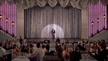 Movie still from “Pepe” (1960), directed by George Sidney – A man standing on a stage in front of an audience; Extreme Wide shot, Low angle