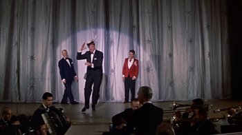 Movie still from “Pepe” (1960), directed by George Sidney – A group of men on a stage performing a dance; Wide shot, Low angle