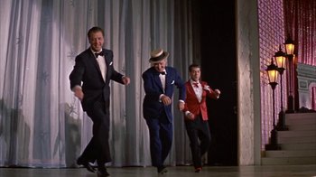 Movie still from “Pepe” (1960), directed by George Sidney – A group of men in tuxedos and hats on a stage; Wide shot, Low angle