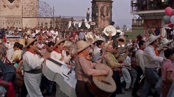 Movie still from “Pepe” (1960), directed by George Sidney – A group of people in a crowd holding musical instruments; Wide shot, High angle