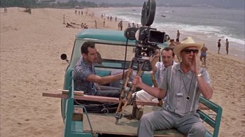 Movie still from “Pepe” (1960), directed by George Sidney – A group of men sitting in the back of a truck on the beach; Wide shot, Over the shoulder angle