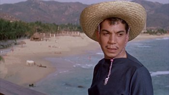 Movie still from “Pepe” (1960), directed by George Sidney – A man wearing a straw hat standing in front of the ocean; Close Up shot, Low angle