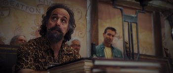 Movie still from “Percy Jackson: Sea of Monsters” (2013), directed by Thor Freudenthal – A man with long hair and a beard sitting at a table; Medium shot, Over the shoulder angle