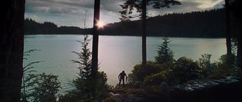 Movie still from “Percy Jackson: Sea of Monsters” (2013), directed by Thor Freudenthal – A man standing on a rock in front of a body of water surrounded by pine trees; Extreme Wide shot, Low angle