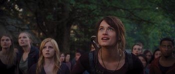 Movie still from “Percy Jackson: Sea of Monsters” (2013), directed by Thor Freudenthal – A woman holding a phone up to her ear while standing in front of a group of people; Close Up shot, Low angle