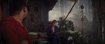Movie still from “Percy Jackson: Sea of Monsters” (2013), directed by Thor Freudenthal – A woman sitting on a bench looking at a tablet; Wide shot, Low angle
