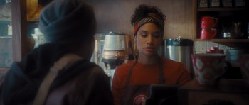 Movie still from “Percy Jackson: Sea of Monsters” (2013), directed by Thor Freudenthal – A woman in an orange shirt is standing in front of a counter; Close Up shot, Over the shoulder angle