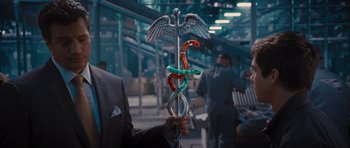 Movie still from “Percy Jackson: Sea of Monsters” (2013), directed by Thor Freudenthal – A man holding a snake and a snake rod; Medium shot, High angle