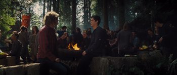 Movie still from “Percy Jackson: Sea of Monsters” (2013), directed by Thor Freudenthal – A group of people sitting around a fire in the woods; Medium shot, Over the shoulder angle
