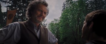 Movie still from “Percy Jackson: Sea of Monsters” (2013), directed by Thor Freudenthal – A person wearing a vest near a forest; Close Up shot, Low angle