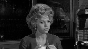 Movie still from “Period of Adjustment” (1962), directed by George Roy Hill – A black and white photo of a woman holding a glass of milk; Close Up shot, Low angle