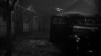 Movie still from “Period of Adjustment” (1962), directed by George Roy Hill – An old truck parked in the rain in front of an old motel; Wide shot, Low angle