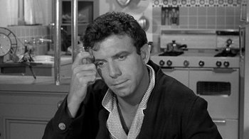 Movie still from “Period of Adjustment” (1962), directed by George Roy Hill – Black and white photograph of a man in a kitchen; Close Up shot, High angle