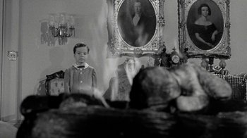Movie still from “Period of Adjustment” (1962), directed by George Roy Hill – A young boy standing in front of a mirror; Medium shot, Over the shoulder angle