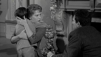 Movie still from “Period of Adjustment” (1962), directed by George Roy Hill – An old photo of a woman and a man and a child; Medium shot, Over the shoulder angle