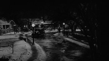 Movie still from “Period of Adjustment” (1962), directed by George Roy Hill – A black - and - white photo of a snowy street at night; Extreme Wide shot, High angle