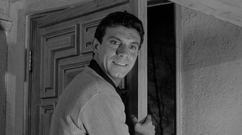 Movie still from “Period of Adjustment” (1962), directed by George Roy Hill – Black and white photograph of a man in front of a door; Medium shot, Low angle
