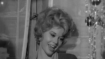 Movie still from “Period of Adjustment” (1962), directed by George Roy Hill – A black - and - white photo of a woman smiling; Close Up shot, Over the shoulder angle