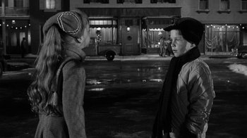 Movie still from “Period of Adjustment” (1962), directed by George Roy Hill – Two people standing on the sidewalk in front of a building; Close Up shot, Over the shoulder angle