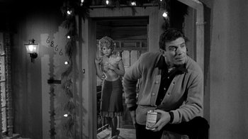 Movie still from “Period of Adjustment” (1962), directed by George Roy Hill – A man and a woman are standing in front of a door; Medium shot, Low angle