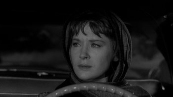 Movie still from “Period of Adjustment” (1962), directed by George Roy Hill – A woman in a hood sitting in a car; Close Up shot, Low angle