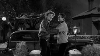 Movie still from “Period of Adjustment” (1962), directed by George Roy Hill – Two men standing next to each other in front of a lamp post; Medium shot, Low angle