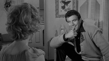 Movie still from “Period of Adjustment” (1962), directed by George Roy Hill – A man and a woman sitting in front of each other in a room; Medium shot, Over the shoulder angle