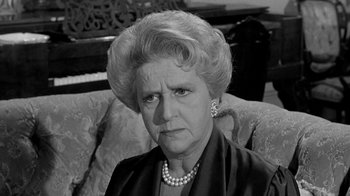Movie still from “Period of Adjustment” (1962), directed by George Roy Hill – An older woman wearing pearls sitting on a couch; Close Up shot, High angle