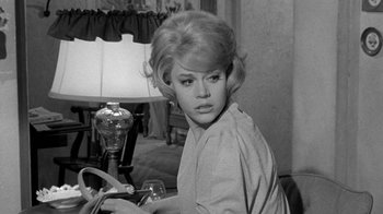 Movie still from “Period of Adjustment” (1962), directed by George Roy Hill – A young blond haired woman holding a wine glass in a living room; Close Up shot, Low angle