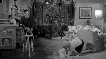 Movie still from “Period of Adjustment” (1962), directed by George Roy Hill – A man and a woman in a living room with a christmas tree in the background; Wide shot, High angle