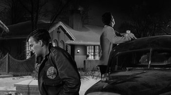 Movie still from “Period of Adjustment” (1962), directed by George Roy Hill – Two men standing next to a car in the snow; Medium shot, Low angle
