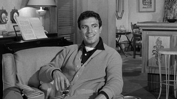 Movie still from “Period of Adjustment” (1962), directed by George Roy Hill – Black and white photograph of a man sitting in a chair holding a glass; Medium shot, Low angle