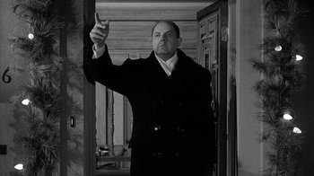 Movie still from “Period of Adjustment” (1962), directed by George Roy Hill – A black and white photo of a man in a suit and tie; Medium shot, Low angle