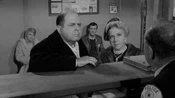 Movie still from “Period of Adjustment” (1962), directed by George Roy Hill – An old photo of a man and a woman and a man sitting at a table; Medium shot, Over the shoulder angle