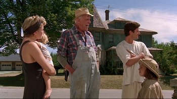 Movie still from “Pet Sematary” (1989), directed by Mary Lambert – An old man standing in front of some people; Medium shot, Low angle