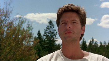 Movie still from “Pet Sematary” (1989), directed by Mary Lambert – A person with trees in the background; Close Up shot, Low angle
