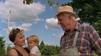 Movie still from “Pet Sematary” (1989), directed by Mary Lambert – An older man holding a young child in his arms; Medium shot, Low angle