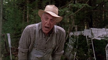 Movie still from “Pet Sematary” (1989), directed by Mary Lambert – An old man in a hat and overalls in the woods; Medium shot, Low angle