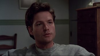 Movie still from “Pet Sematary” (1989), directed by Mary Lambert – A person wearing a gray shirt; Close Up shot, Low angle