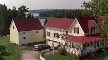 Movie still from “Pet Sematary” (1989), directed by Mary Lambert – An aerial view of a house with a car parked in front of it; Extreme Wide shot, High angle