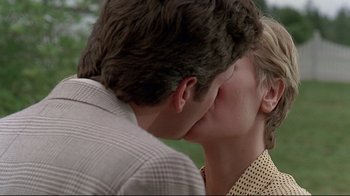 Movie still from “Pet Sematary” (1989), directed by Mary Lambert – A man and a woman kissing each other in a park; Close Up shot, Over the shoulder angle